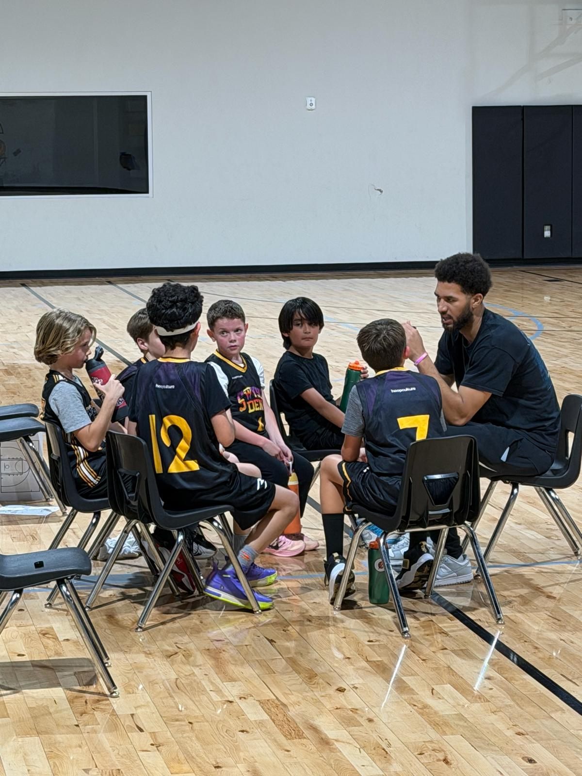 A coach talks strategy with his Swysh Den team between plays