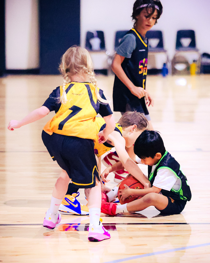 Young players scramble for a loose ball on the court at Swysh Den